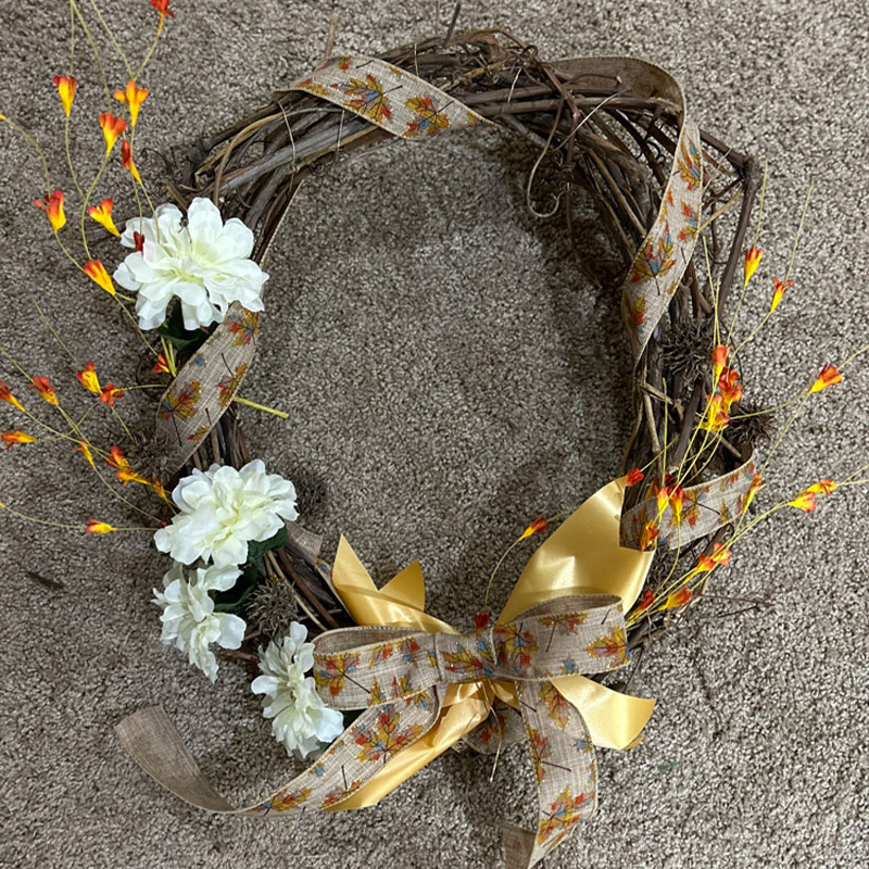 wreath with brown flowers and brown and yellow bows made during a wreath making demonstration